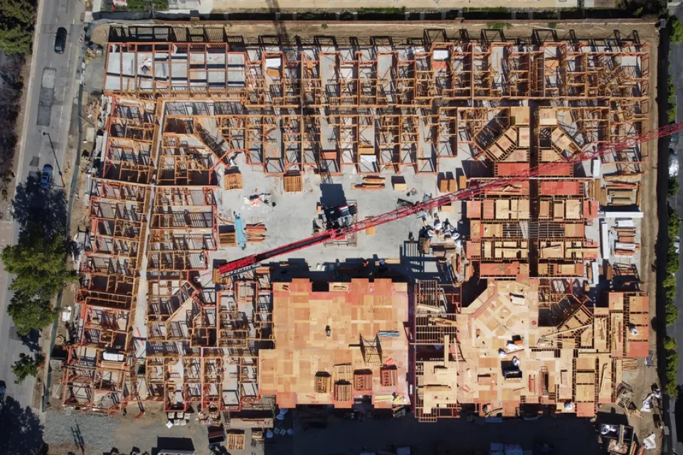 An overhead image of a large wooden building as it's being constructed.
